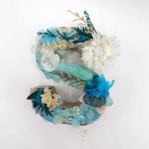 Letra de flores preservadas en tonos azules